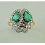 An emerald and diamond lovers hearts ring, the diamonds totalling approximately 1.