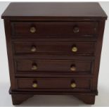 A mahogany miniature chest of four drawers with brass handles and bracket feet, 24.