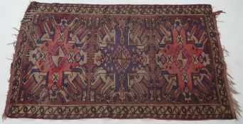 A woven and pile eastern rug with three hooked medallions on mauve field within two line borders,