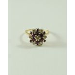 A ruby and diamond 18 carat gold cluster ring, the seven brilliant cuts totalling approximately 0.