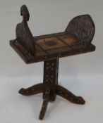 A middle Eastern stool, overlaid with embossed metal mounts on square pedestal and four flared feet,