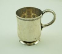 A silver mug with a reeded band, loop handle and foot, London 1957 by Garrard & Co.