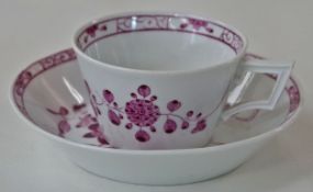 A Meissen cup and saucer, decorated in puce,