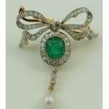 An emerald and diamond bow brooch with a pearl drop,