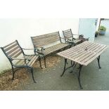 A cast iron and wooden slat garden suite, comprising of a rectangular table, a bench,