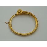 An archaeological revival gold hinged bangle, with a rams head terminal,