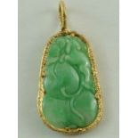 A carved jade pendant within a textured gold rim mount, carved as peaches, 5.