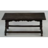 An oak and beech stool with turned legs linked by rectangular stretchers, 47cm high, 94cm wide,