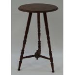 An early 20th century aesthetic movement style mahogany occasional table with turned legs linked by