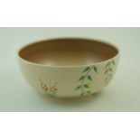 A Clarice Cliff bowl, painted with leafy branches in a stylised flowering landscape,