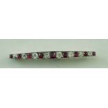 A ruby and diamond bar brooch, alternate graduated set with nine rubies and eight diamonds,