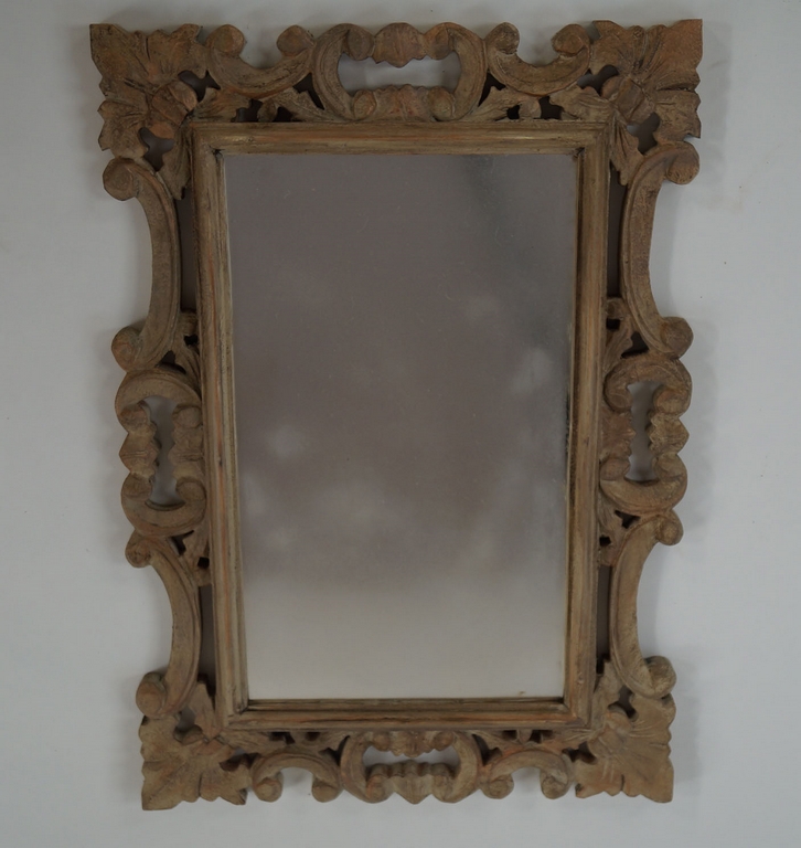 A wall mirror with carved limed frame,