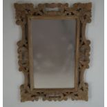 A wall mirror with carved limed frame,