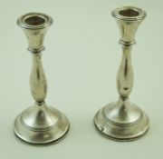 A pair of silver round candlesticks with baluster stems and reeded bands and capitals,
