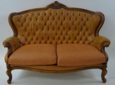 A walnut show frame two seat sofa with leather button back, on cabriole legs,