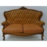 A walnut show frame two seat sofa with leather button back, on cabriole legs,