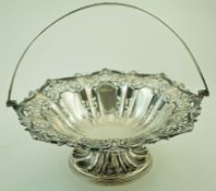 A silver round pedestal fruit basket with a swing handle,