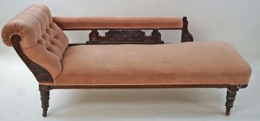 An Edwardian oak framed chaise longue, with button back, turned legs and casters,