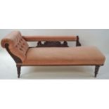 An Edwardian oak framed chaise longue, with button back, turned legs and casters,