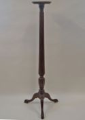 A mahogany torchere with reeded and carved pedestal on three cabriole legs,