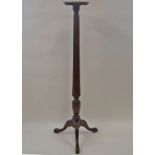 A mahogany torchere with reeded and carved pedestal on three cabriole legs,