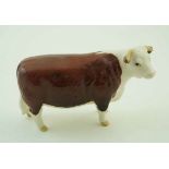 A Beswick figure of a Hereford cow, printed factory marks in black and painted “Ch of Champions”.