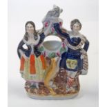 A 19th century Staffordshire pottery watch stand in the form of two highlanders flanking a whippet,