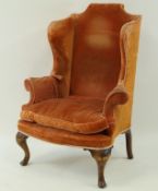 A wing back armchair with loose cushion,