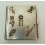 A Russian silver cigarette case decorated with various symbols to the cover,