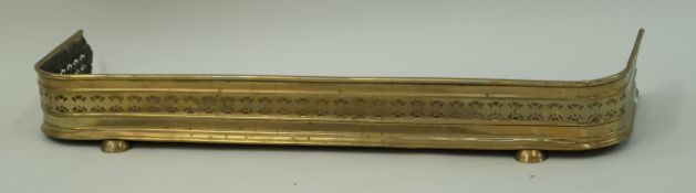A Victorian brass pierced fender on plinth base,