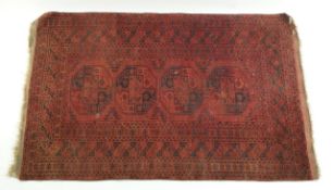 A decorative rug with four lozenges on a red field within multiple borders,
