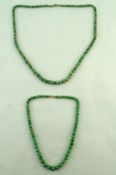 A row of graduated jade beads; with another similar shorter row of jade beads;