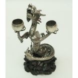 A Chinese silver figure of a dragon holding two bowls, by Hung Chong, on a carved wooden stand, 22.