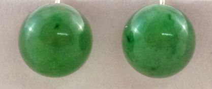 A pair of jade ear screw earrings, the hemispherical stones of approximately 11.