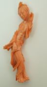 A carved coral of a Chinese lady waving with her left hand and holding her skirt with the other
