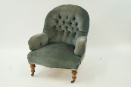 A Victorian button back chair on turned legs with brass and ceramic casters