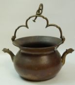 A copper cauldron with shaped swing handle and two dolphin shaped spouts, 49cm high,