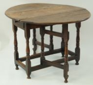 A late 18th century oak oval drop leaf table,