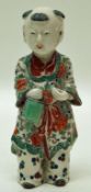 A Chinese porcelain figure, painted in coloured enamels with flowers on his robe,