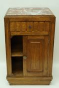 A French Art Deco bedside cupboard with inset marble top, with one drawer above a cupboard door,