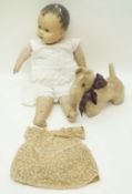 An early 20th century doll with composite head and fabric body wearing a cotton dress and an