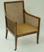 An Edwardian mahogany bergere chair  with caned back and arms,