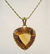 A large heart shaped citrine pendant, stamped '585' to the bale and to the chain,