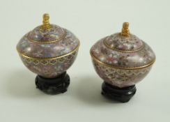 A pair of cloisonné bowls and covers with gilded figural finials decorated with two tone flowers in