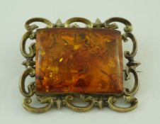 A Victorian rectangular brooch, with a panel of clarified amber to the centre, 5.
