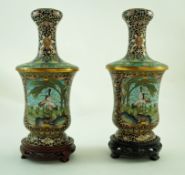 A pair of shaped cloisonné vases each decorated with storks within a landscape within scrolling