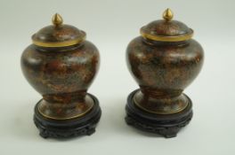 A pair of cloisonné vases of baluster form with domed covers on pierced hardwood stands decorated