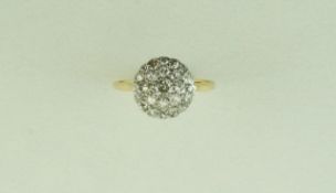 A diamond cluster ring, stamped '18ct', the central Swiss cut stone enclosed by single cuts,