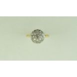 A diamond cluster ring, stamped '18ct', the central Swiss cut stone enclosed by single cuts,