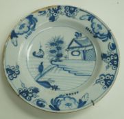 A late 18th century Dutch Delft charger, painted in blue with a boat in a river landscape, 35.